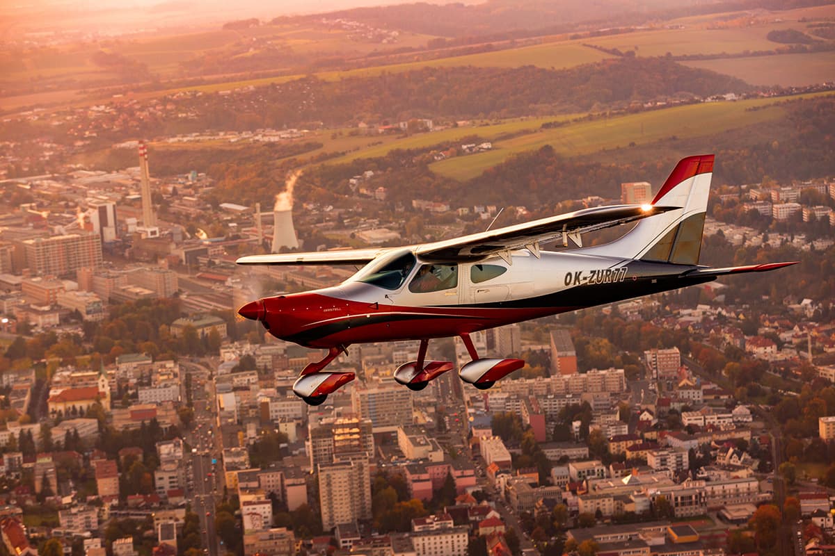 Bristell B8M banking over a town at golden hour