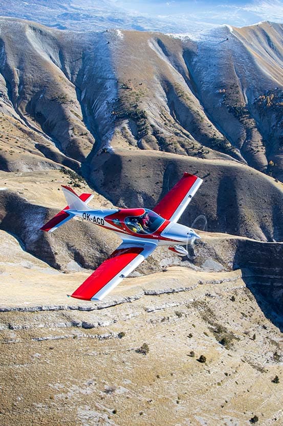 Bristell B23 flying over a mountain ridge